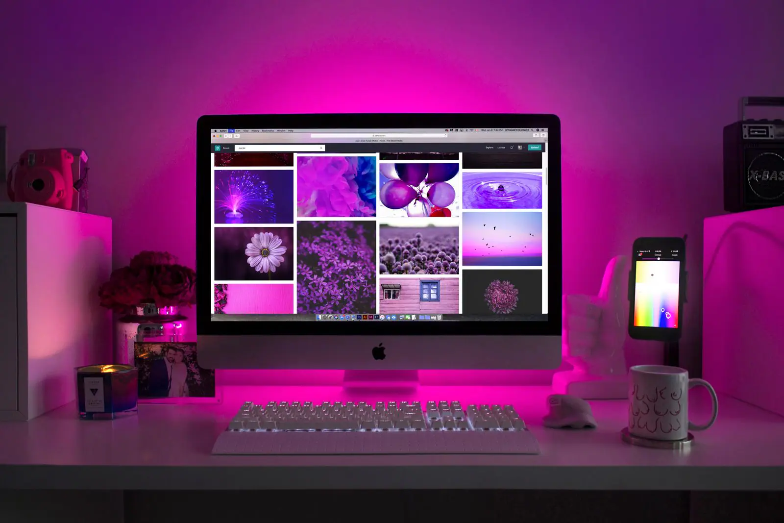Desktop computer showing a design layout under purple neon light