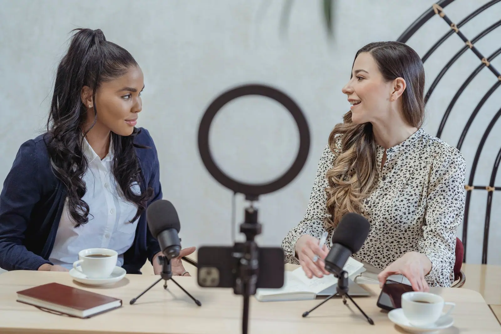 Two women recording a conversation with a phone on a ring light