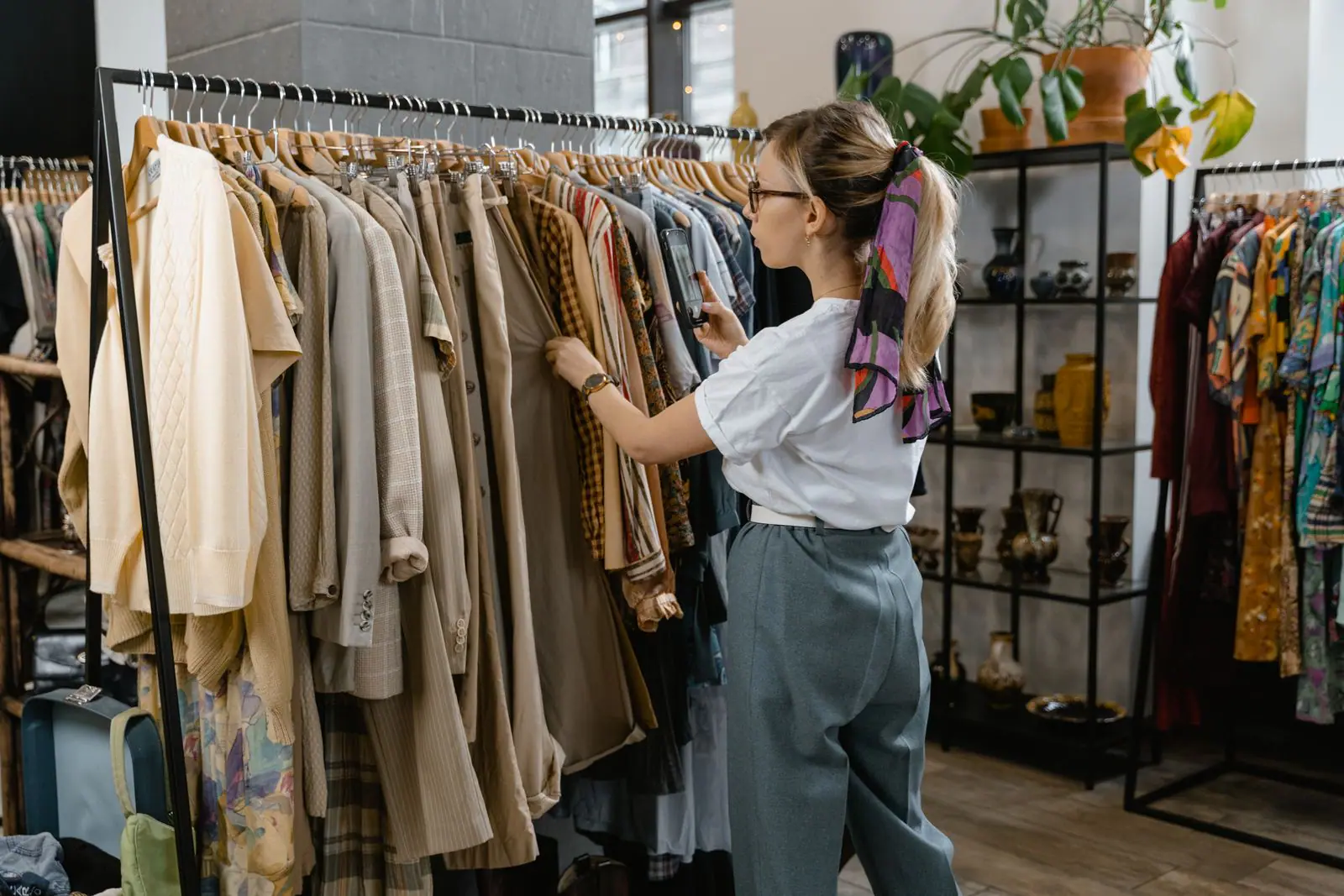 Woman browsing a rail of clothes in a small boutique